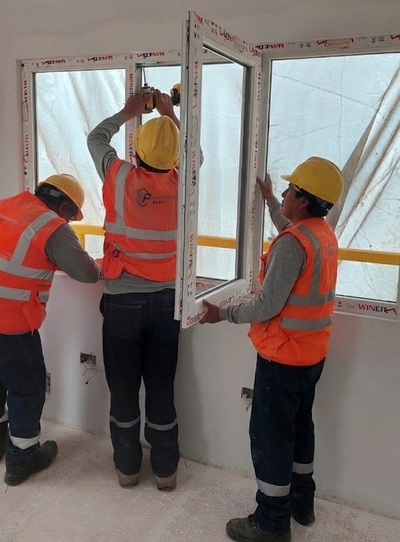 Personal con EPP instalando vidrio